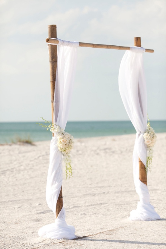 arche nuptiale en bambou décorée de draps blanc et fleurs